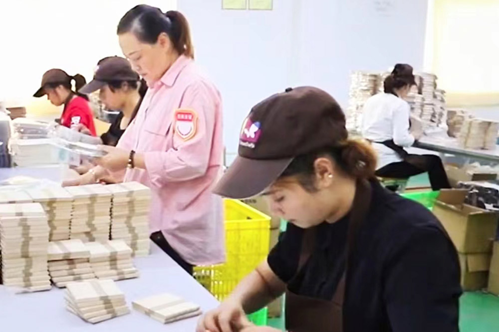 A worker meticulously inspects the finished product